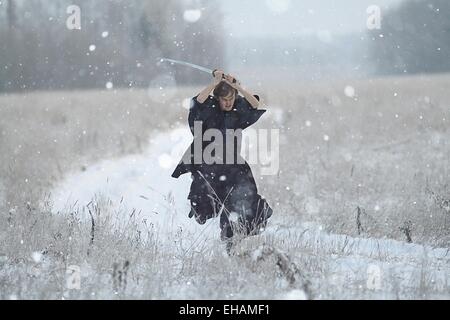 running samurai wearing a kimono in a winter field dressed in black, frost Stock Photo