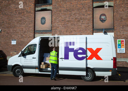 FedEx FED EX delivery vehicle deliveries with doors open and courier delivering tracked goods for Albert Dock, Liverpool, Merseyside. UK Stock Photo