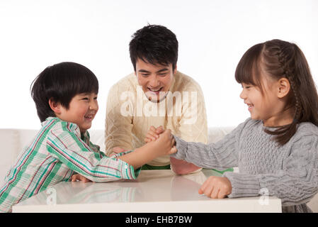Boys and girls in an arm-wrestling father do referees Stock Photo