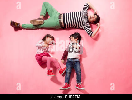 Father and children playing lying on the ground