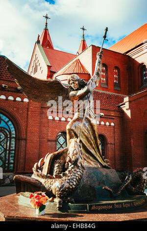 Statue of Archangel Michael with outstretched wings, thrusting spear into dragon before Catholic Church of St. Simon and St. Hel Stock Photo