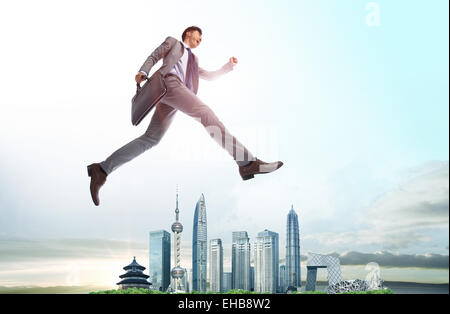 The business man jumps over the city Stock Photo