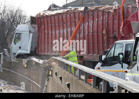 London, UK. 11th March, 2015. Truck overturned spewing rubbish into the subway path at Sun in the Sands roundabout, Blackheath Stock Photo