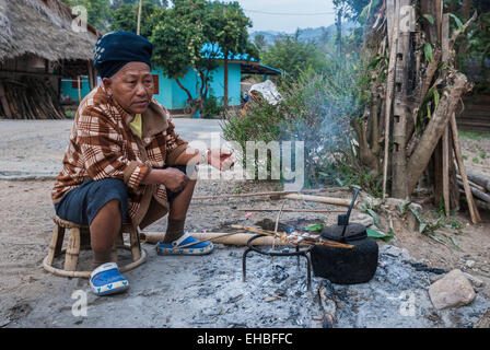 Very remote  Yaou village located north of Chiang Rai, Thailand. This woman was cooking her food in the street.