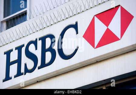 Business, Finance, Banking, HSBC Bank sign on a high street bank building with metal pigeon control spikes above it. Stock Photo