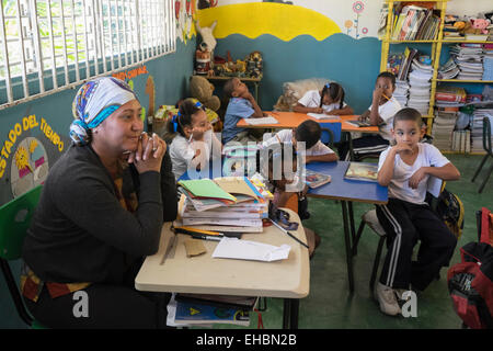 Primary school teacher with children studying in classroom of a village school near Puerto Plata, Dominican Republic, Caribbean Stock Photo