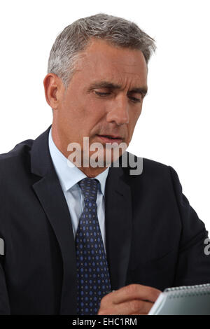 A portrait of a mature businessman taking notes. Stock Photo