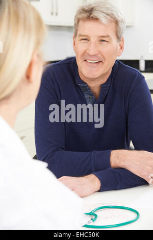 Mature Man Meeting With Female Doctor In Surgery Stock Photo
