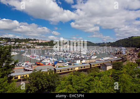 The Kingswear to Paignton steam train and coaches at Kingswear Station platform, yacht marina beyond and Dartmouth in distance Stock Photo