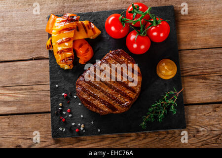 grilled beef steak with vegetables on a wooden surface Stock Photo