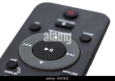 Closeup of a dark grey remote control, focused on the Play/Pause button, isolated on white background Stock Photo