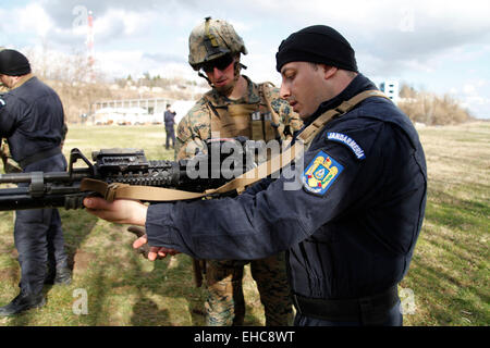 A US Marine explains the operation of an M4 carbine to a member of the Romanian Jandarmeria at the Romanian intelligence service shooting range February 26, 2015 in Bucharest, Romania. Stock Photo