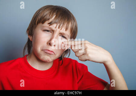 Boy, teenager, twelve years in a red shirt, showing that Stock Photo