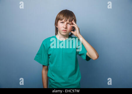 Boy, teenager, twelve years old, in a green t-shirt holding