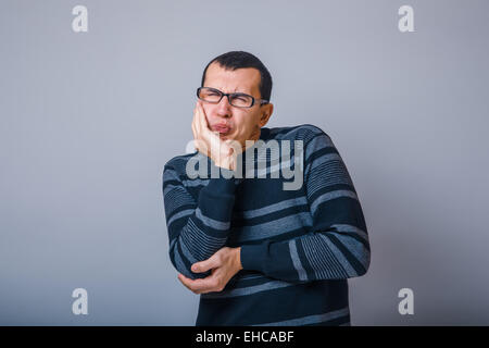 male of European appearance brunet in a striped sweater put his Stock Photo