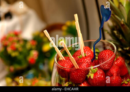 Fresh Strawberries with toothpicks stuck in them, placed in a glass bowl Stock Photo