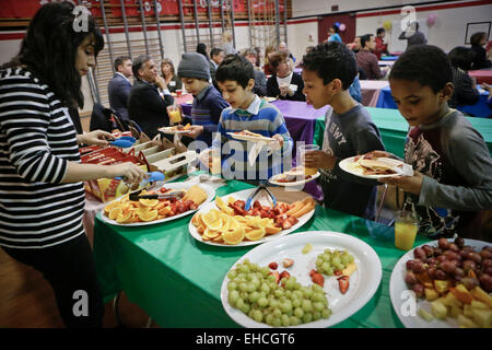 Vancouver, Canada. 11th Mar, 2015. Children line up for the food during the Pancake Breakfast event in Vancouver, Canada, March 11, 2015. About 450 kids under poverty were served with breakfast during the 22nd annual Pancake Breakfast event organized by KidSafe Project Society. The event aimed to raise the awareness of the children poverty issue. © Liang Sen/Xinhua/Alamy Live News