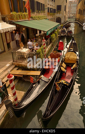 Two Venetian gondolas moored outside a restaurant, small canal, Venice, Veneto, Italy Stock Photo