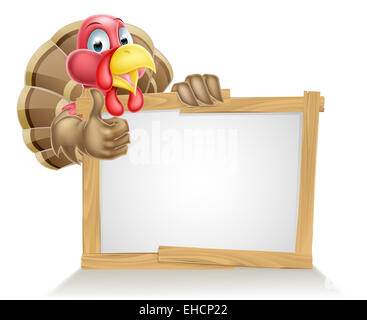 Happy cartoon turkey bird above a sign and giving a thumbs up Stock Photo