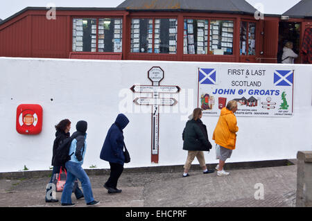 Walkers passing the sign showing distances to Land's End, John O'Groats, Caithness, Scotland
