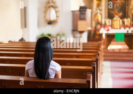 Woman prays in a church Stock Photo