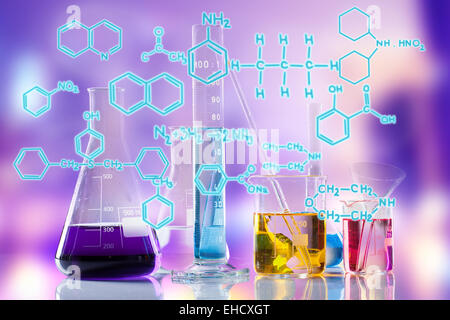 Laboratory tubes with colored liquids inside and formula on foreground Stock Photo