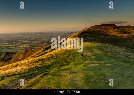 Two people walking towards the British Camp, an Iron Age hill fort, Herefordshire Beacon, Malvern Hills, Worcestershire, UK Stock Photo