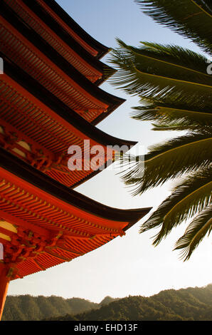 Nature complements the ornate, red lacquer, five-storied pagoda (Gojunoto) at Toyokuni Shrine (Senjokaku) Miyajima Island, Japan Stock Photo