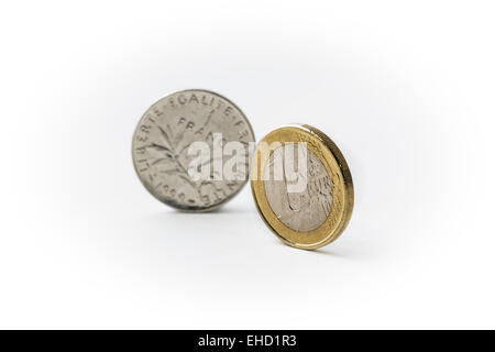 One Euro Coin and Old One French Franc Coin standing side by side with focus on the Euro and Franc in the background Stock Photo