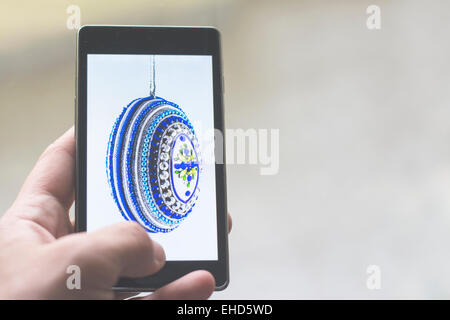 Easter greetings on smart phone with colorful easter egg image Stock Photo