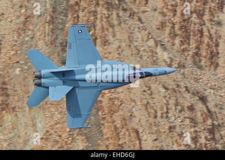 Close Up Topside View Of A US Navy F/A-18E Super Hornet Jet Fighter Banking Steeply In The Sidewinder Low Level Route. Stock Photo