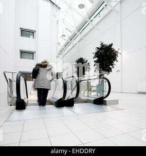 People in office centre on escalator Stock Photo