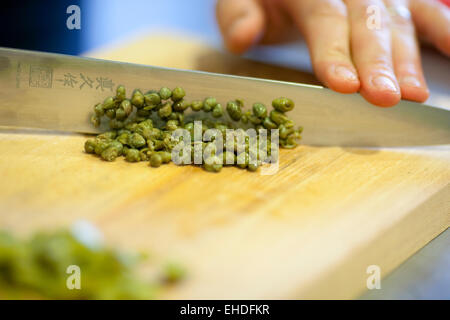 capers knife chopping board action Stock Photo