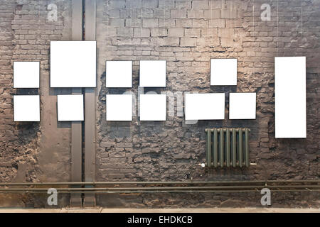 Empty frames on brown brick wall in museum Stock Photo