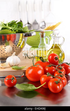 Spinach leaves in strainer with tomatoes Stock Photo