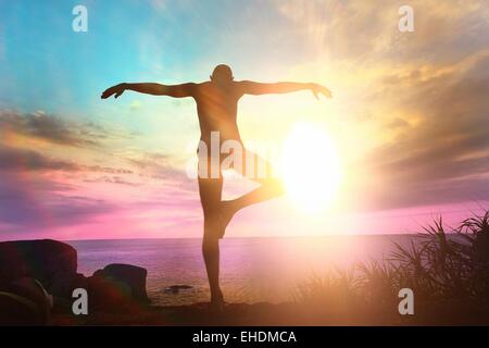 Yogi meditating at sunset on the sea Stock Photo