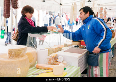 A customer makes a purchase or dairy products at the Canterbury Italian market Stock Photo