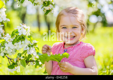 Happy little girl in spring sunny park Stock Photo