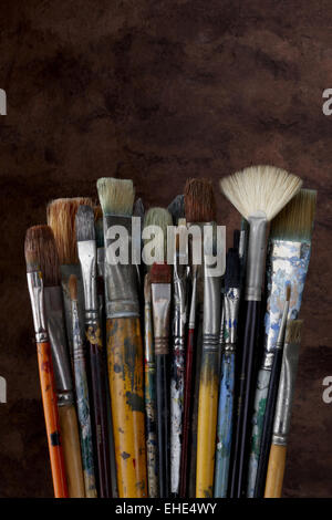 close up of artist paint brushes on dark textured background Stock Photo