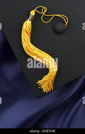 Black mortarboard, blue gown, yellow tassel Stock Photo