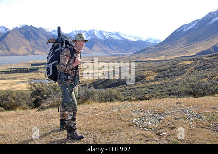 A successful hunter rests with a trophy Himalayan tahr (Hemitragus jemlahicus)  in his backpack Stock Photo