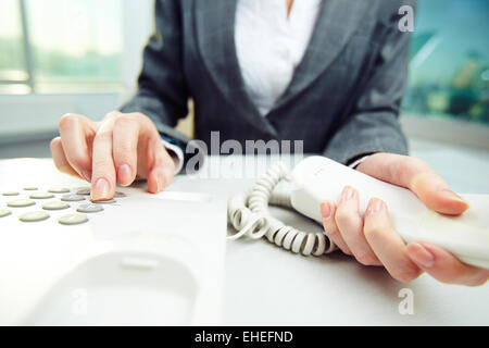 Close-up of female hand pushing buttons on telephone Stock Photo