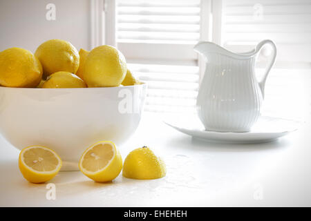 Lemons in large bowl on table Stock Photo