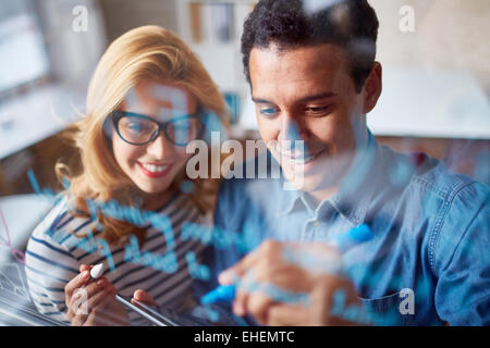 Two colleagues writing on glass Stock Photo