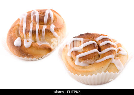 Two cinnamon buns with icing on white background. Stock Photo