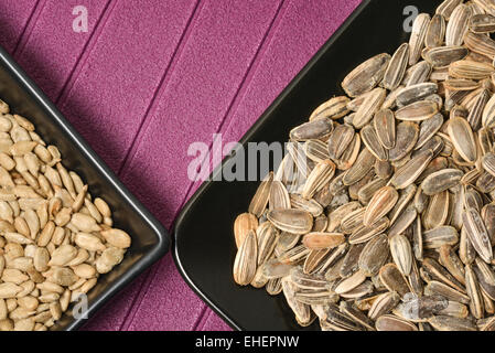 Sunflower seeds arranged in ceramic black with purple background Stock Photo
