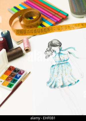 closeup of fashion designer workspace with sketches and designing equipment