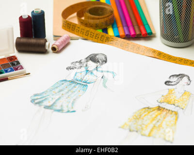 closeup of fashion designer workspace with sketches and designing equipment
