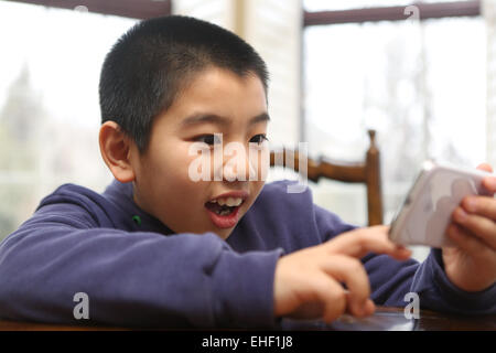 The boy using a mobile phone to play games Stock Photo