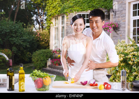 The young couple cook in the outdoor kitchen Stock Photo